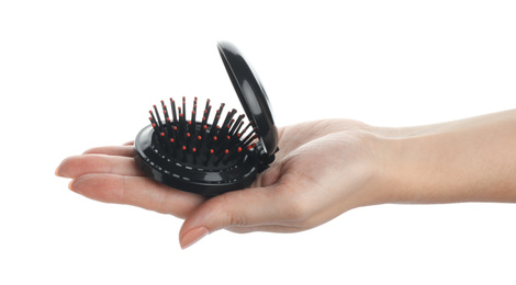 Photo of Woman holding round folding hair brush with mirror on white background, closeup