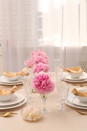 Photo of Stylish table setting with beautiful peonies and fabric napkins indoors