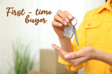 Image of First-time buyer. Woman holding key in her new house, closeup