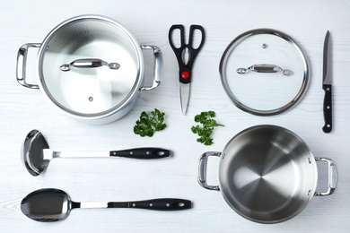Photo of Flat lay composition with clean cookware on white wooden background
