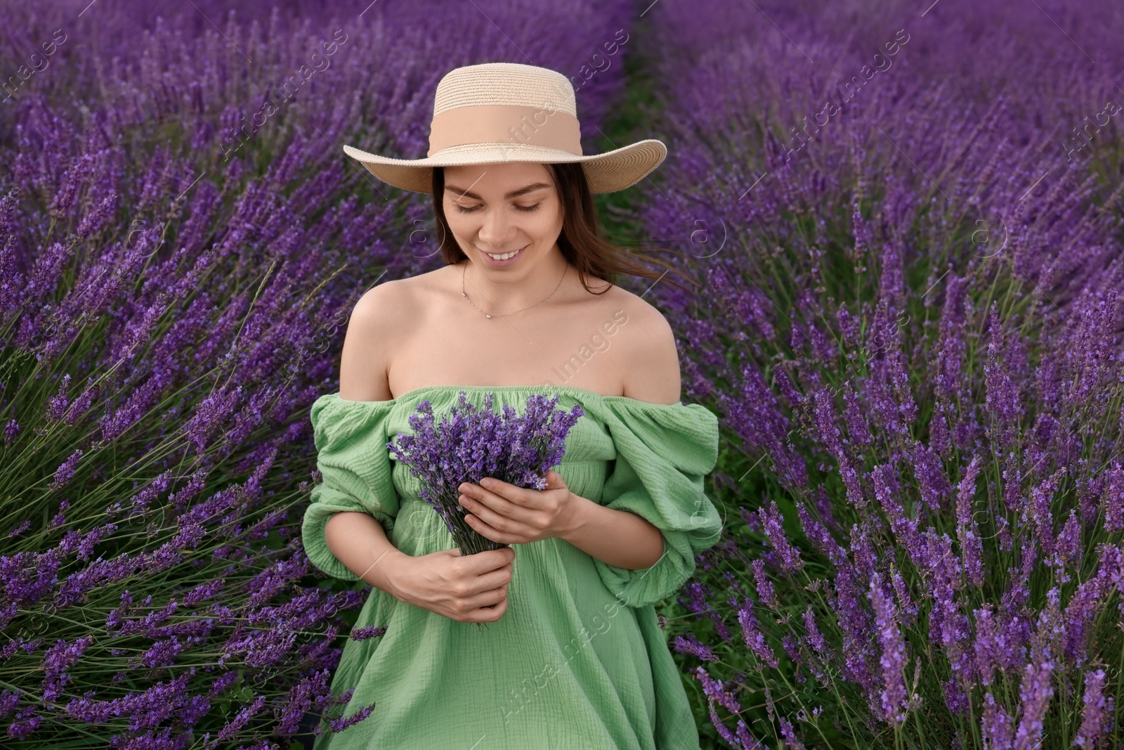 Photo of Smiling woman with bouquet in lavender field