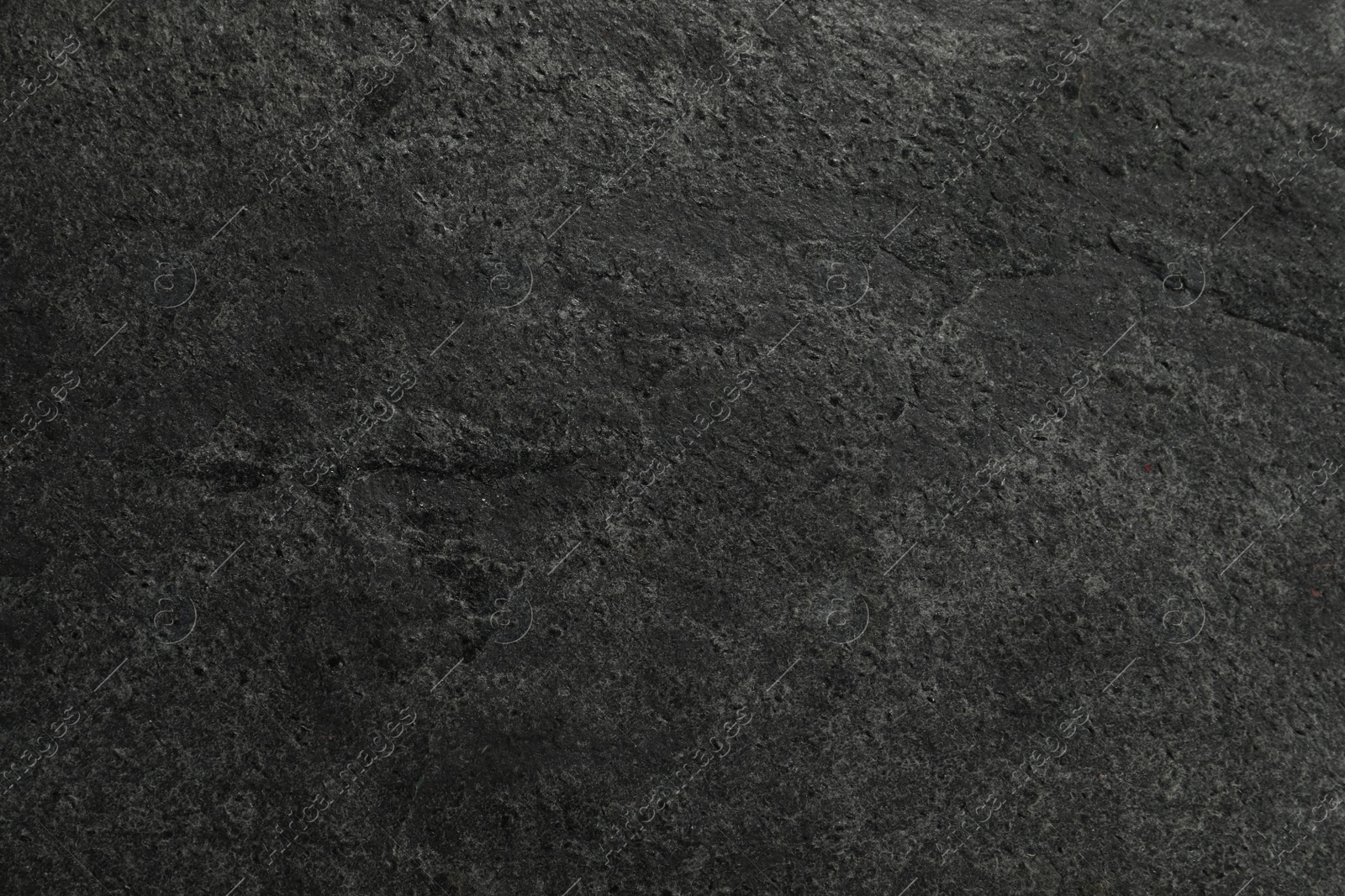 Photo of Texture of dark grey stone surface as background, closeup