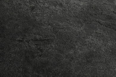 Photo of Texture of dark grey stone surface as background, closeup