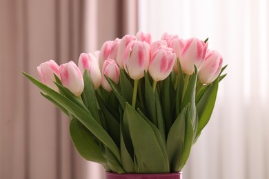 Beautiful bouquet of fresh pink tulips indoors