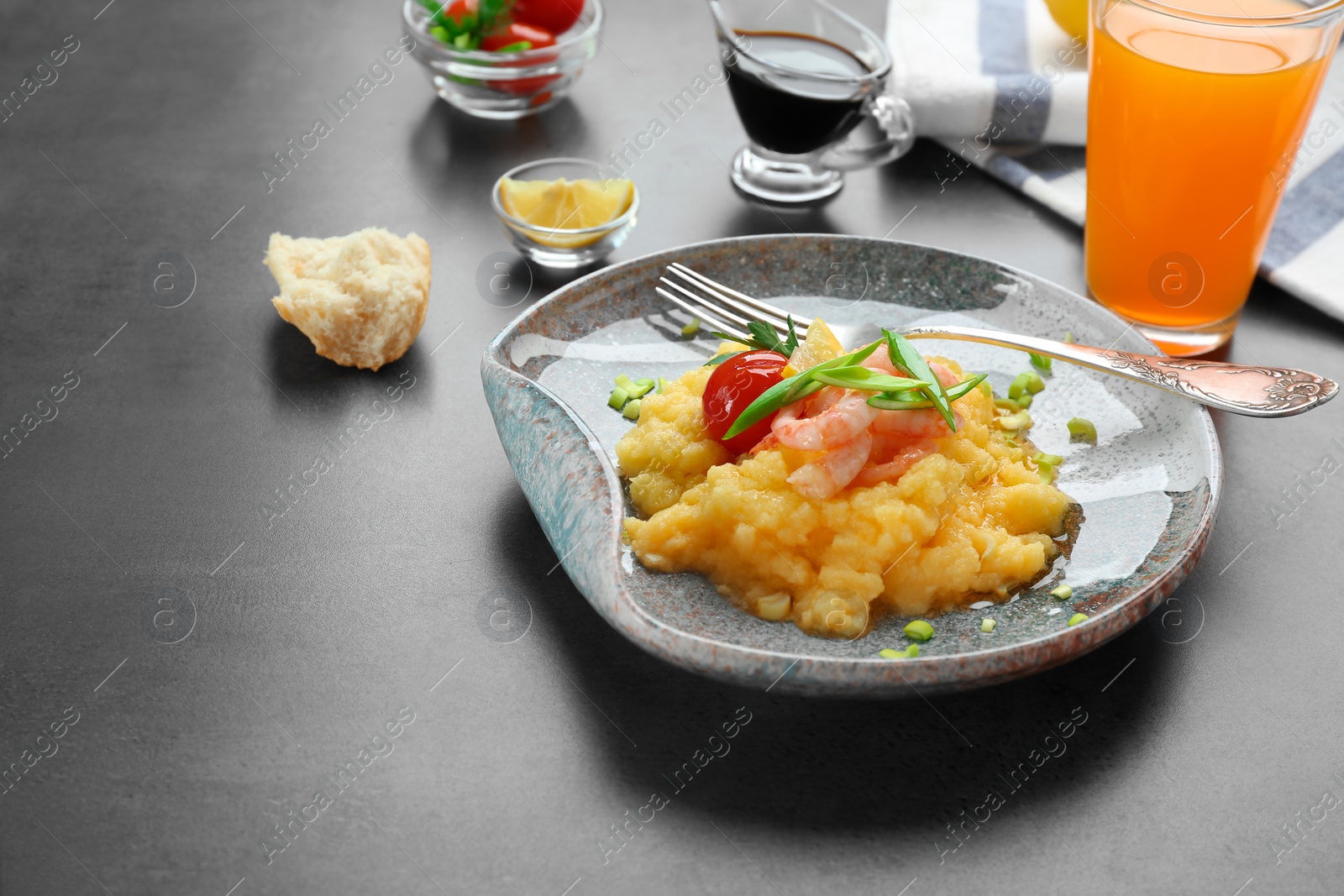 Photo of Plate with fresh tasty shrimp and grits on table