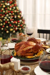 Photo of Festive dinner with delicious baked turkey and wine on table indoors. Christmas celebration