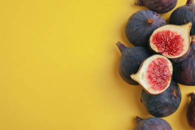 Photo of Delicious ripe figs on yellow background, flat lay. Space for text