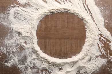 Imprint of plate on wooden table with flour, top view