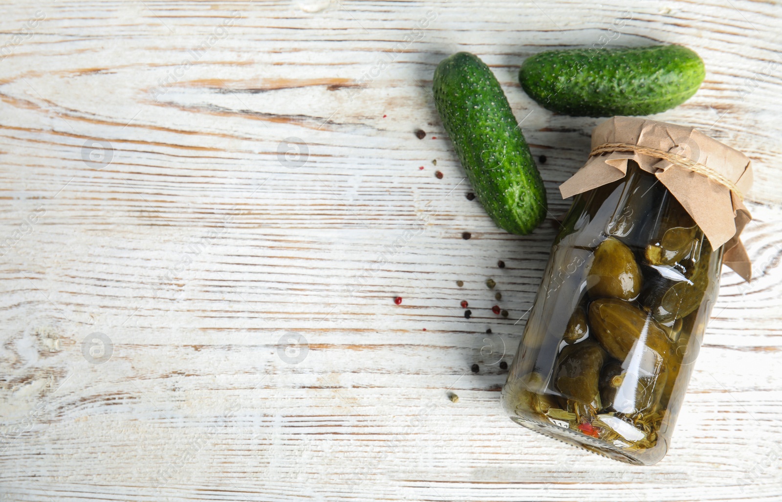 Photo of Flat lay composition with jar of pickled cucumbers on white wooden table, space for text