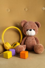 Photo of Baby songs. Toy bear, headphones and cubes on armchair