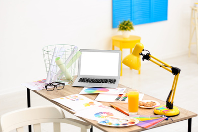 Photo of Modern designer's workplace with laptop and watercolor palette