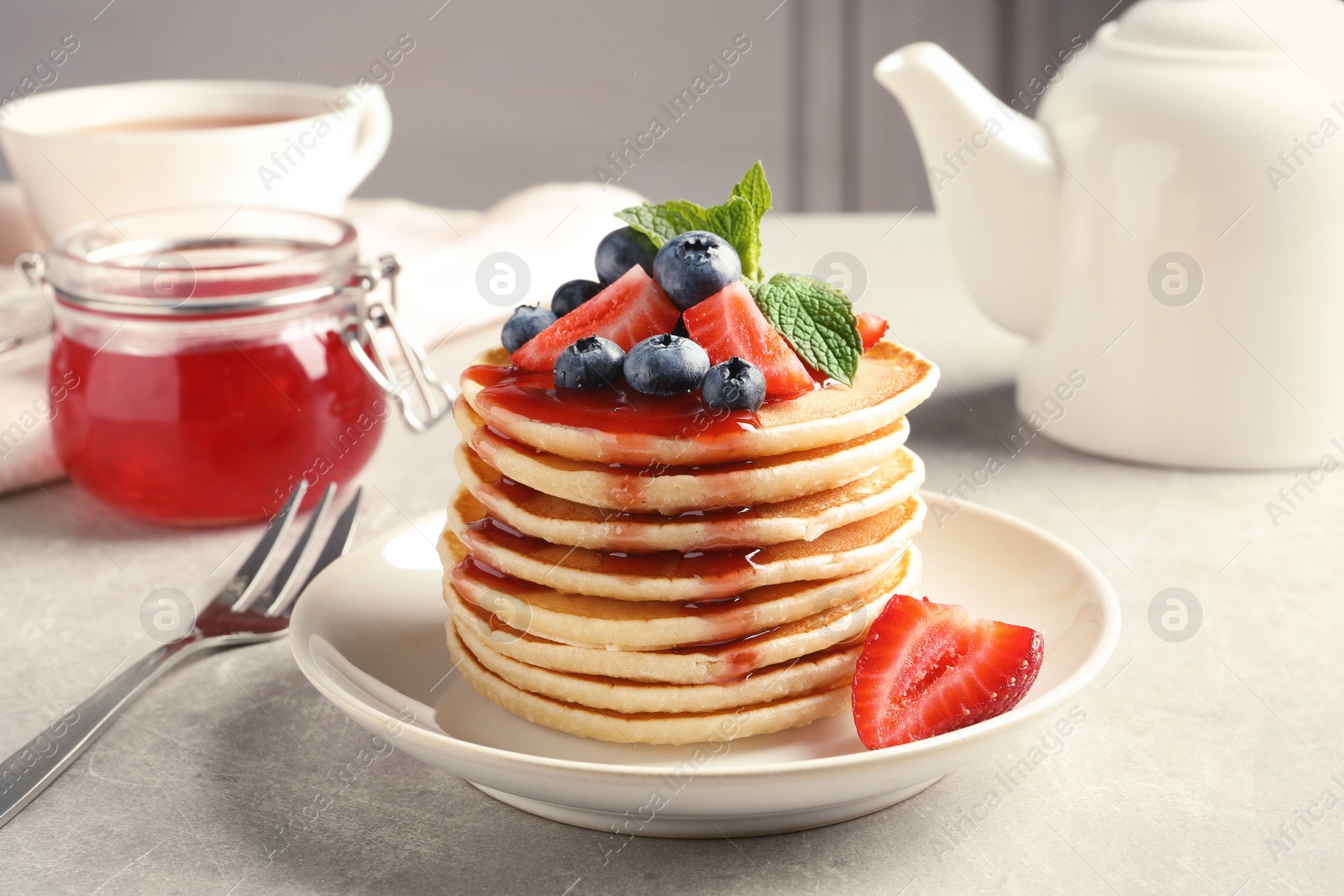 Photo of Plate with pancakes and berries on table