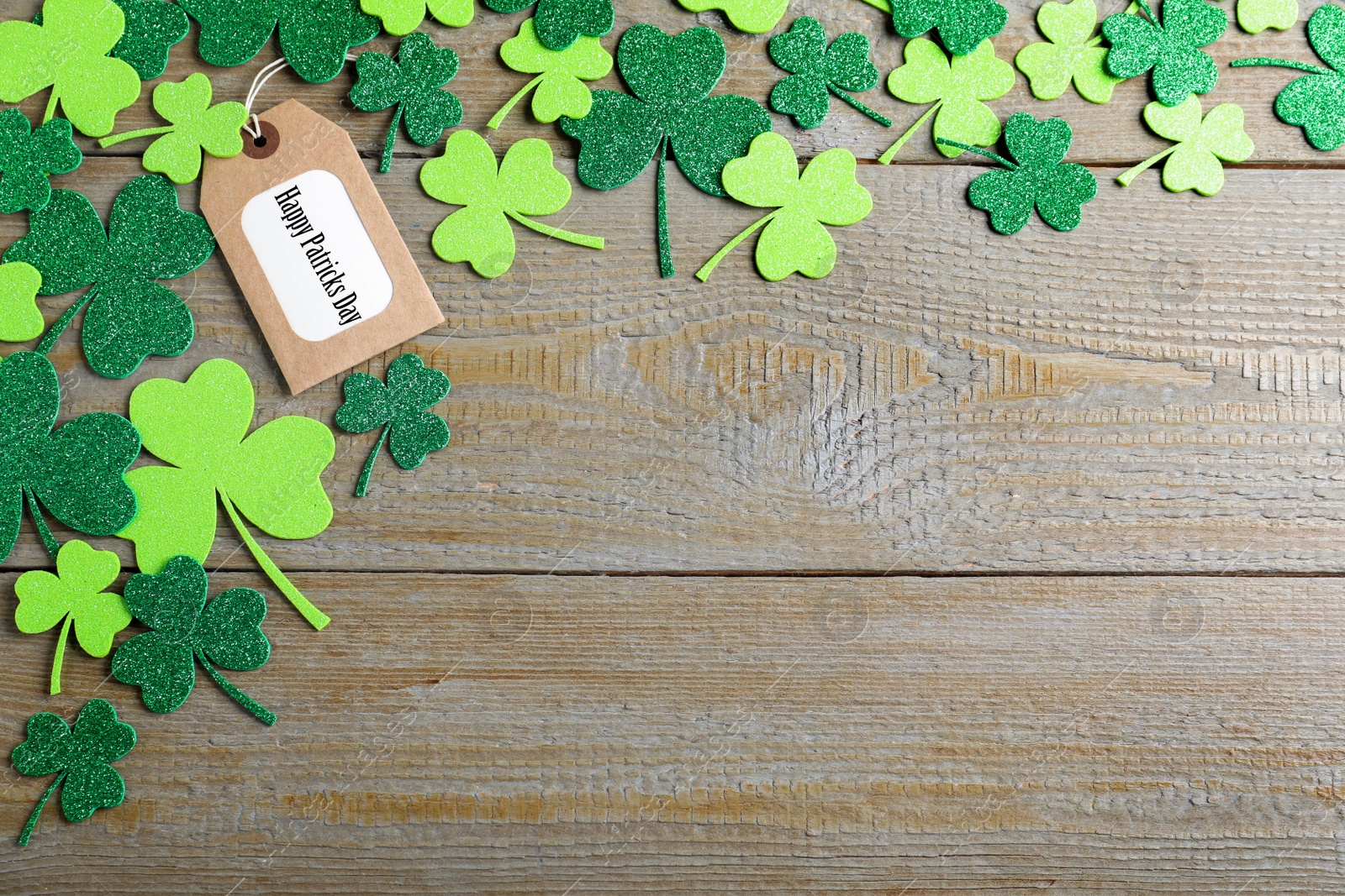 Photo of Flat lay composition with clover leaves on wooden table, space for text. St. Patrick's Day celebration