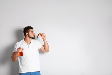 Handsome man with pizza and beer on white background, space for text