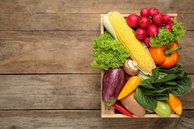 Different fresh vegetables on wooden table, top view. Space for text