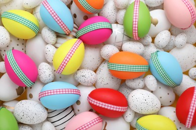 Photo of Festively decorated Easter eggs as background, top view