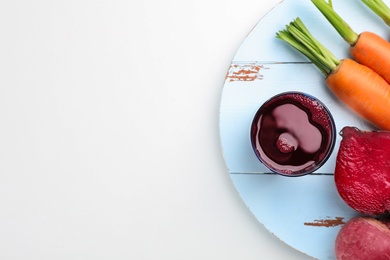 Photo of Glass with fresh beet juice and ingredients on white background, top view