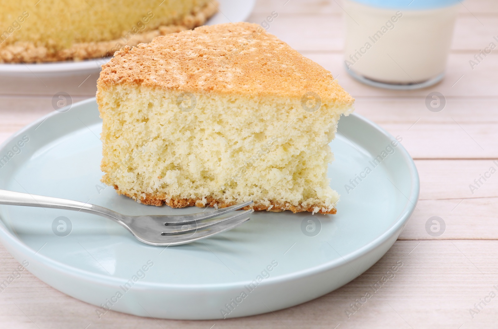 Photo of Piece of tasty sponge cake on white wooden table, closeup