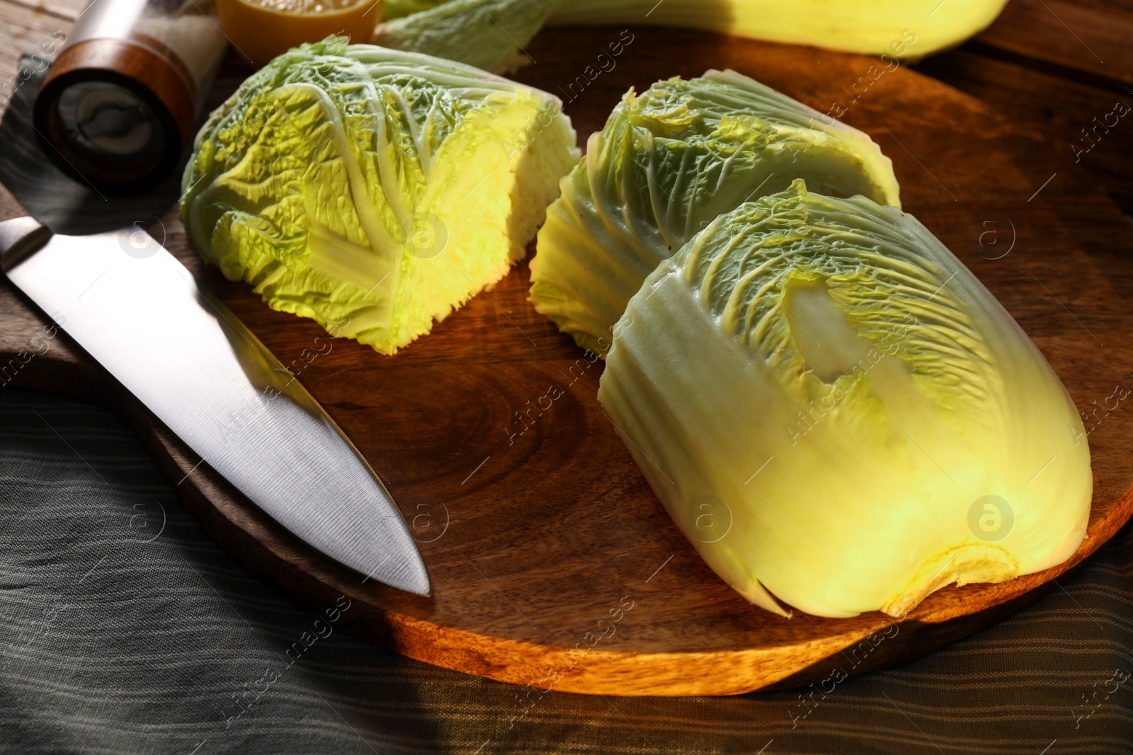 Photo of Fresh Chinese cabbage and knife on wooden table, closeup