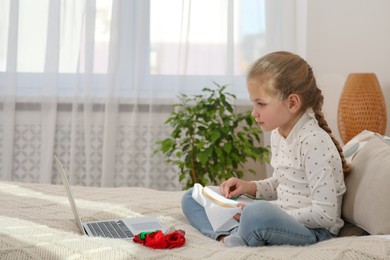Photo of Little girl learning to embroider with online course at home. Space for text