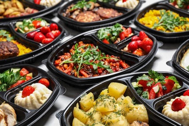 Photo of Lunchboxes with different meals on white table. Healthy food delivery