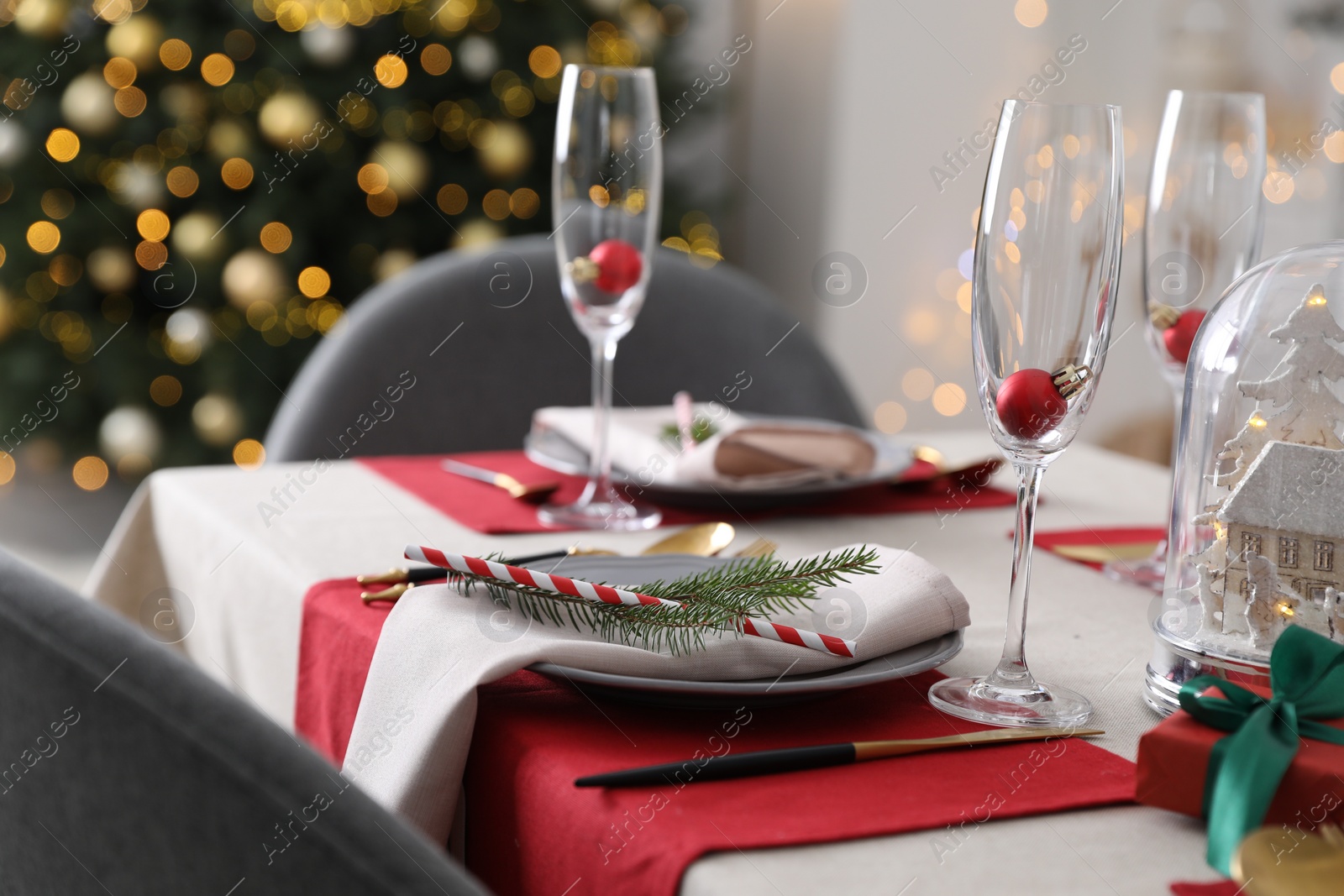 Photo of Christmas table setting with festive decor and dishware indoors