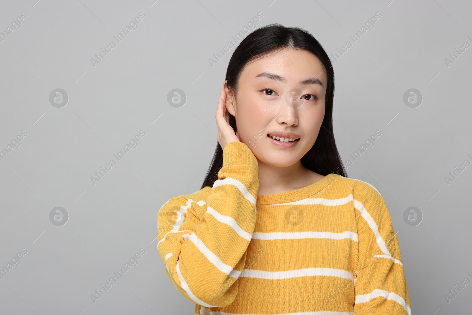 Photo of Portrait of smiling woman on grey background. Space for text