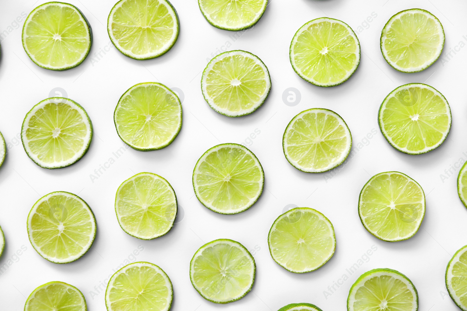 Photo of Slices of fresh juicy limes on white background, flat lay