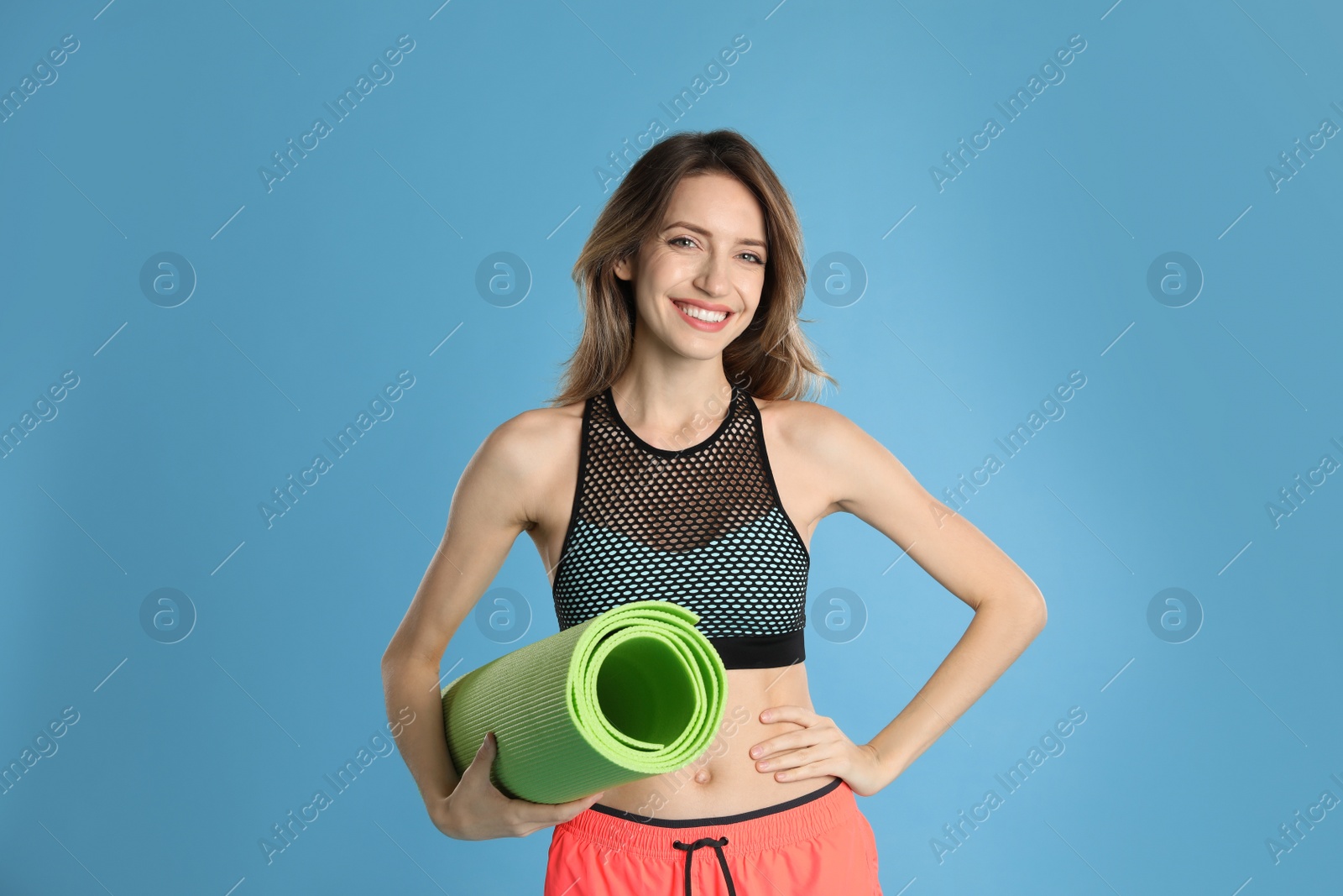 Photo of Beautiful woman with yoga mat on turquoise background