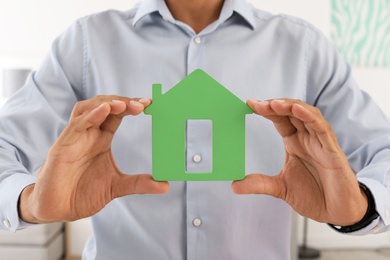 Real estate agent holding house model, closeup