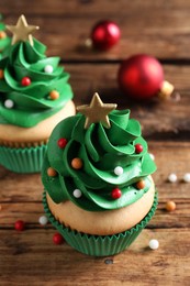 Photo of Christmas tree shaped cupcakes on wooden table