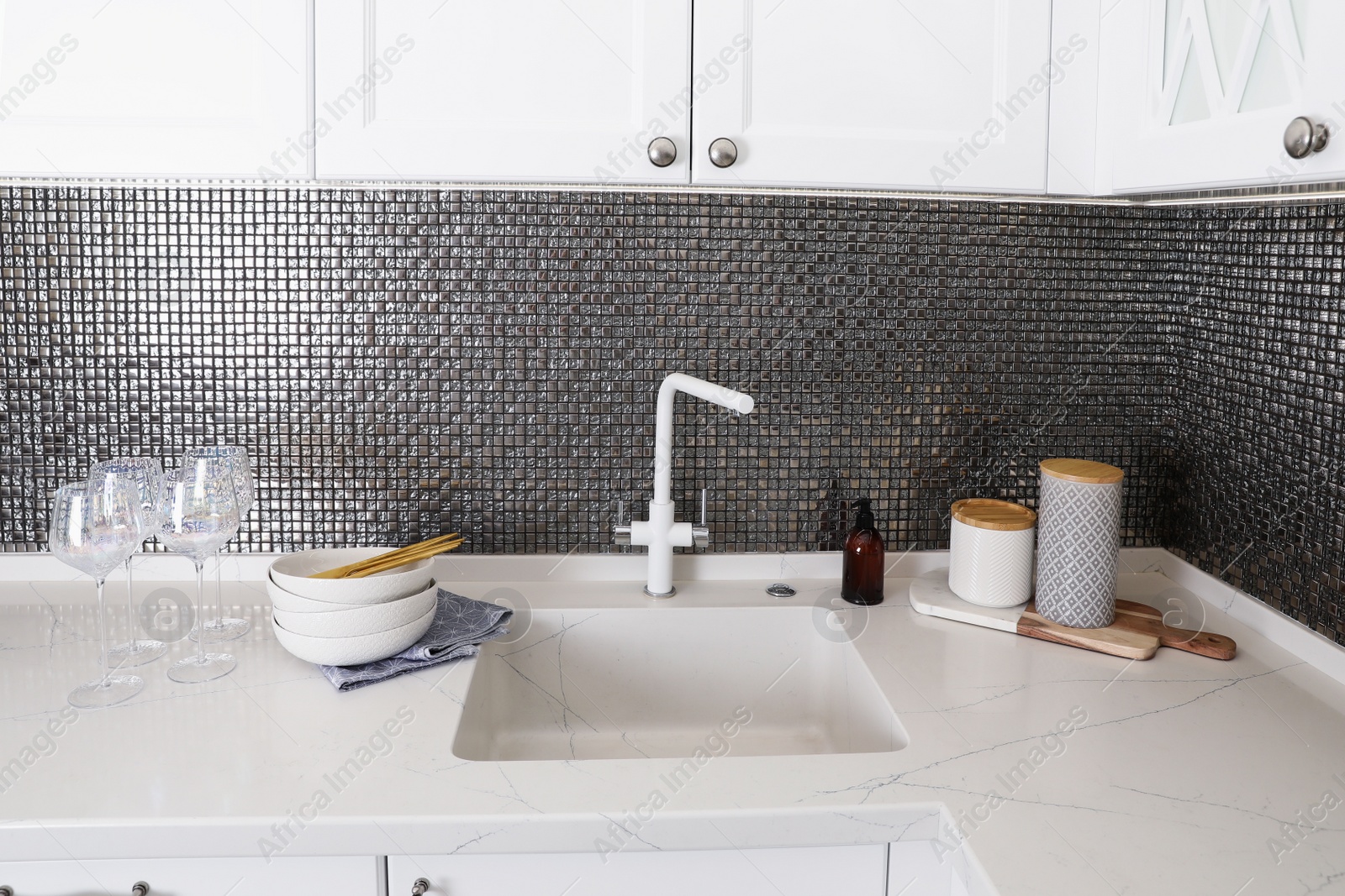 Photo of Beautiful ceramic dishware and glasses on countertop in modern kitchen