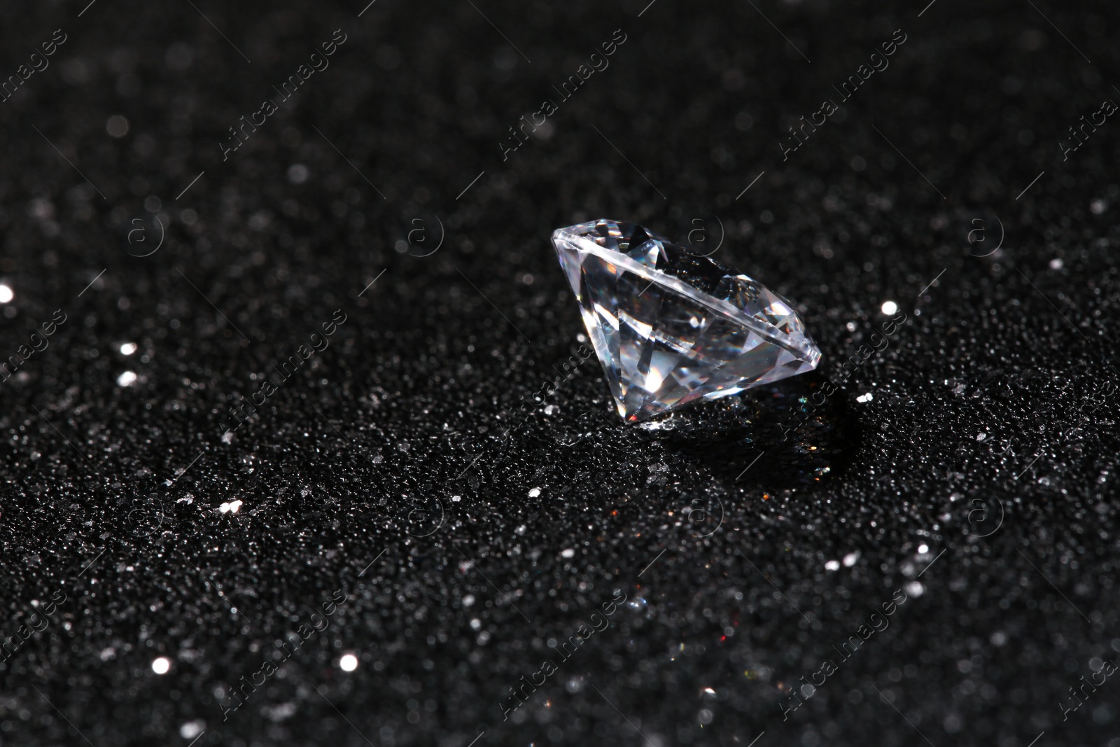Photo of Beautiful dazzling diamond on dark shiny background