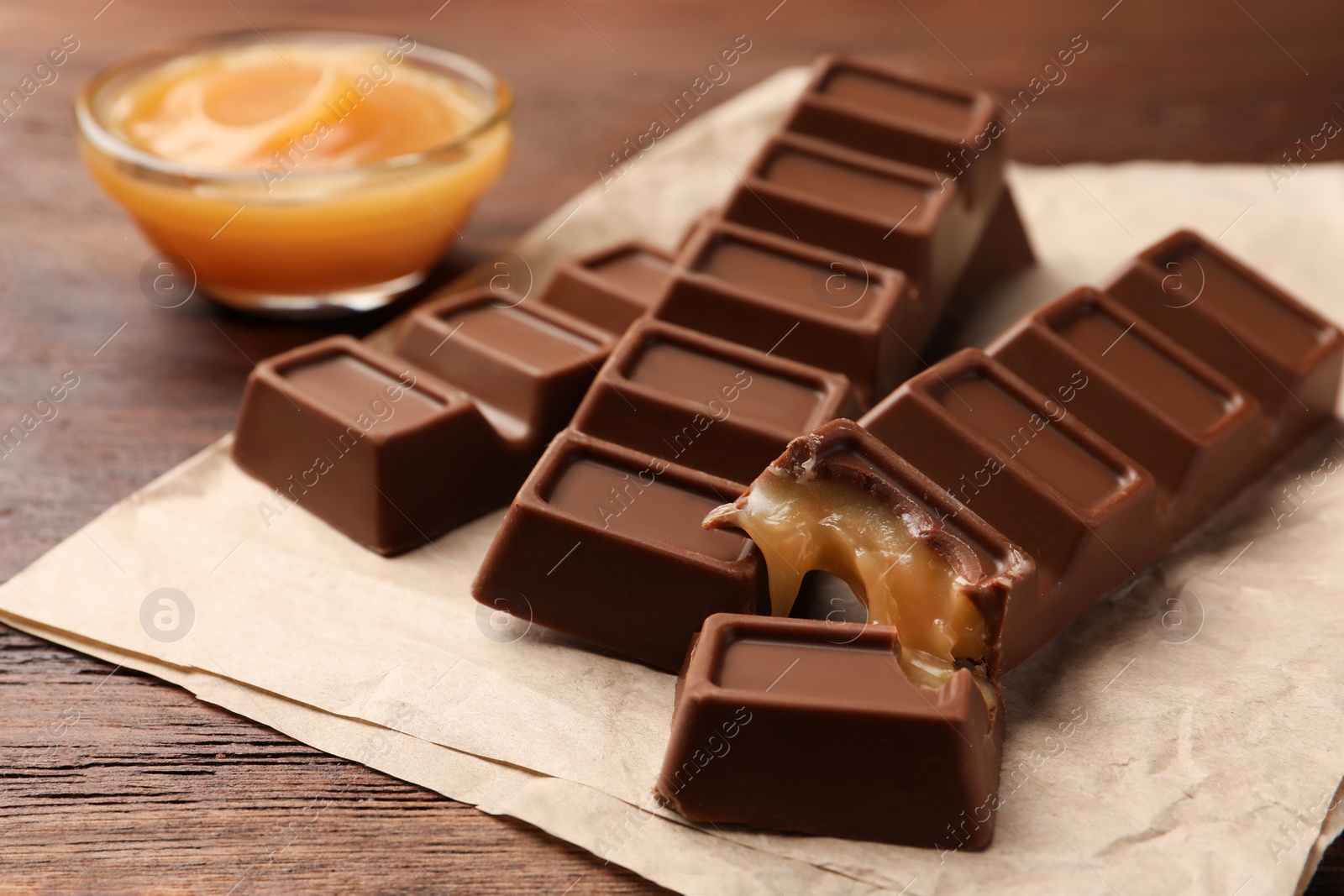 Photo of Tasty chocolate bars on wooden table, closeup