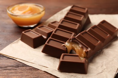 Tasty chocolate bars on wooden table, closeup