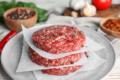 Photo of Raw meat cutlets for burger on white wooden table, closeup