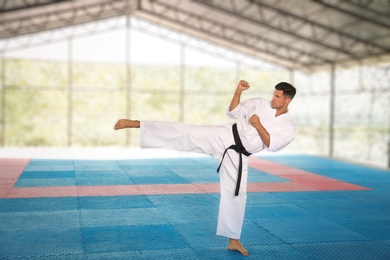 Photo of Professional coach showing karate moves at gym