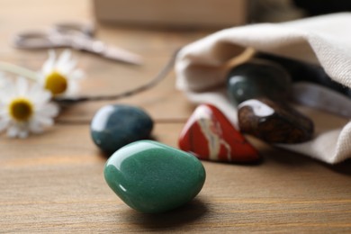 Different healing gemstones on wooden table, closeup