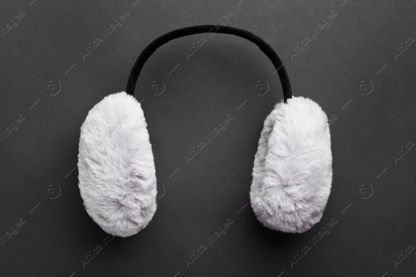 Photo of Stylish winter earmuffs on black background, top view