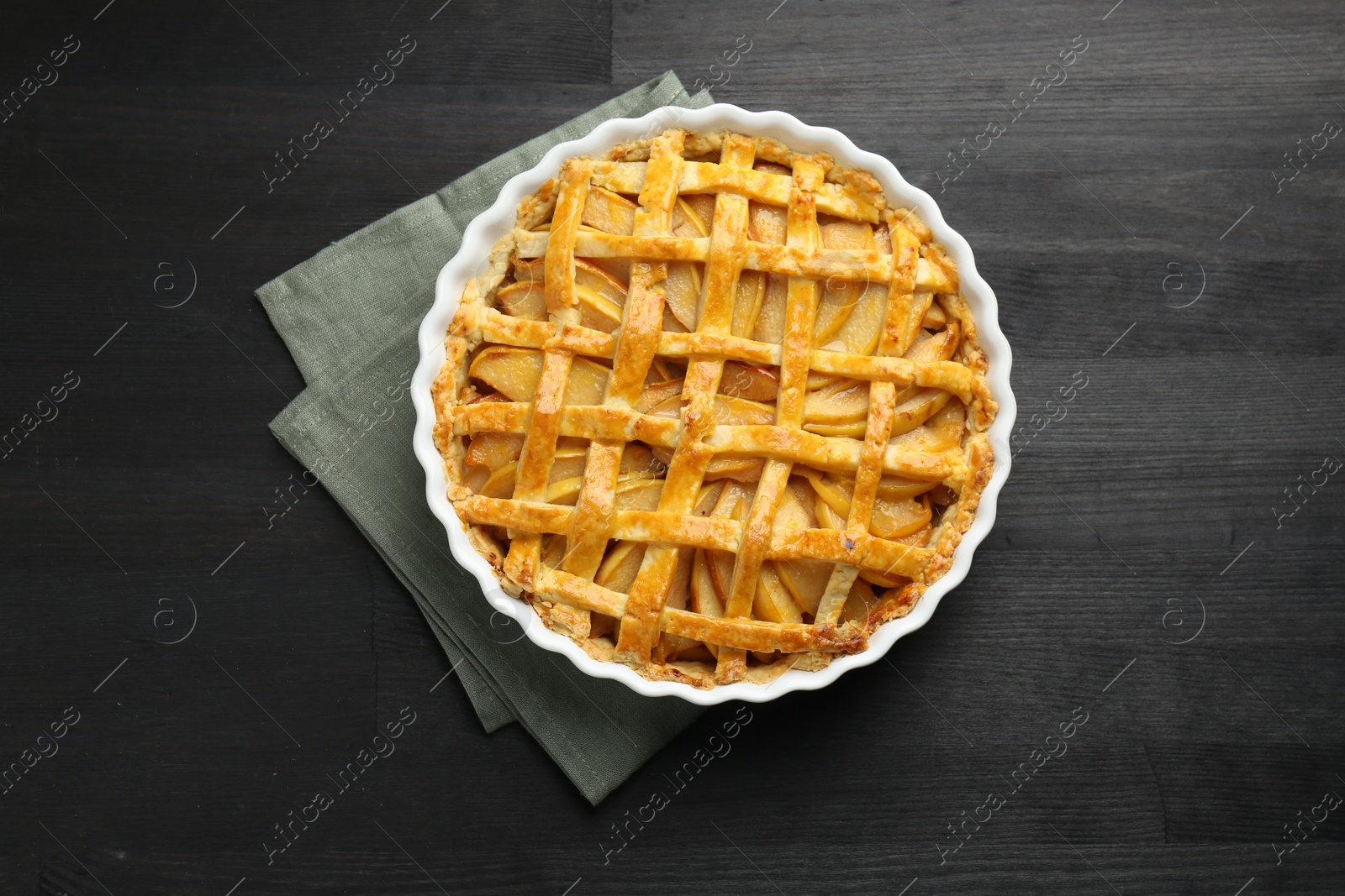 Photo of Tasty homemade quince pie on black wooden table, top view
