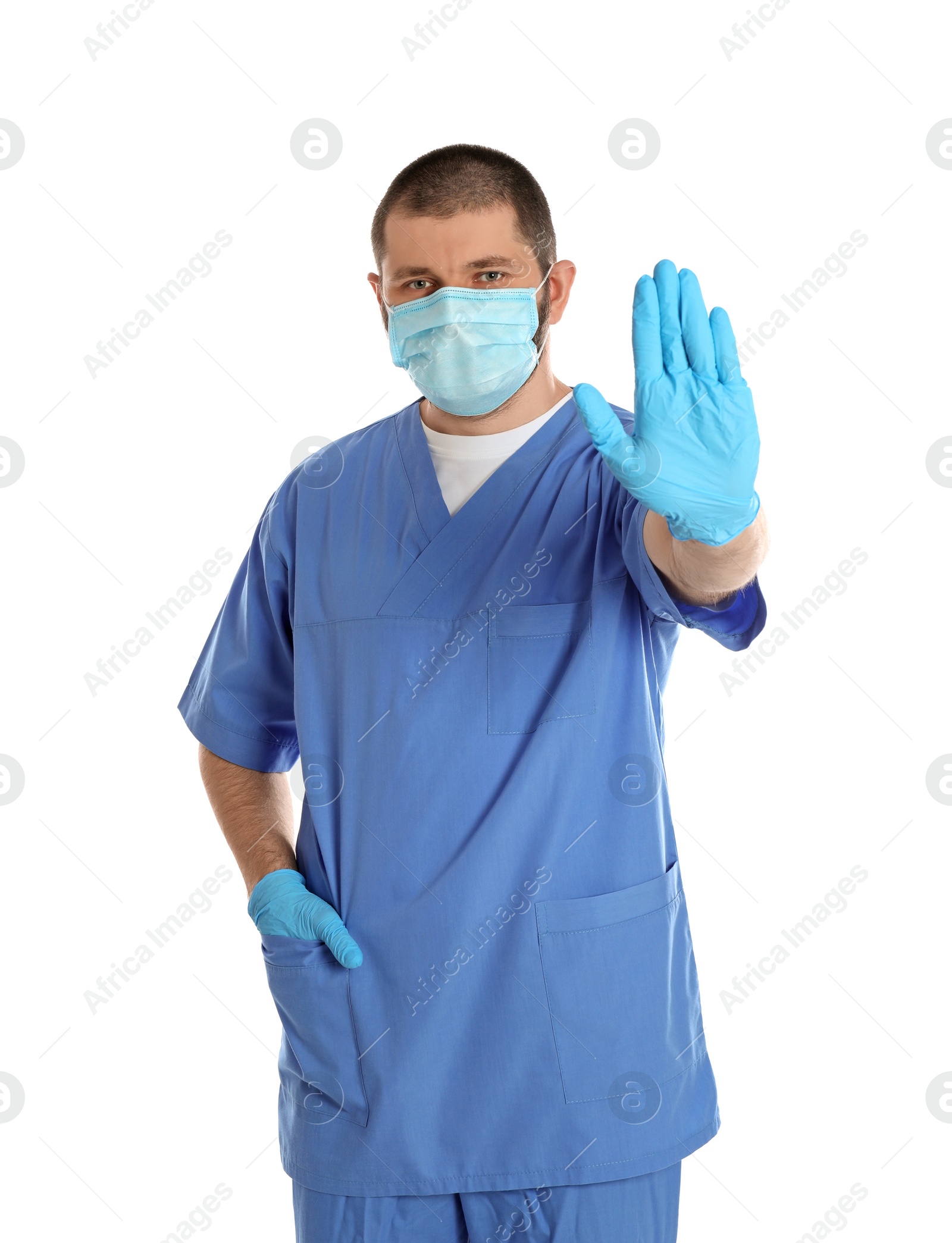 Photo of Doctor in protective mask showing stop gesture on white background. Prevent spreading of coronavirus