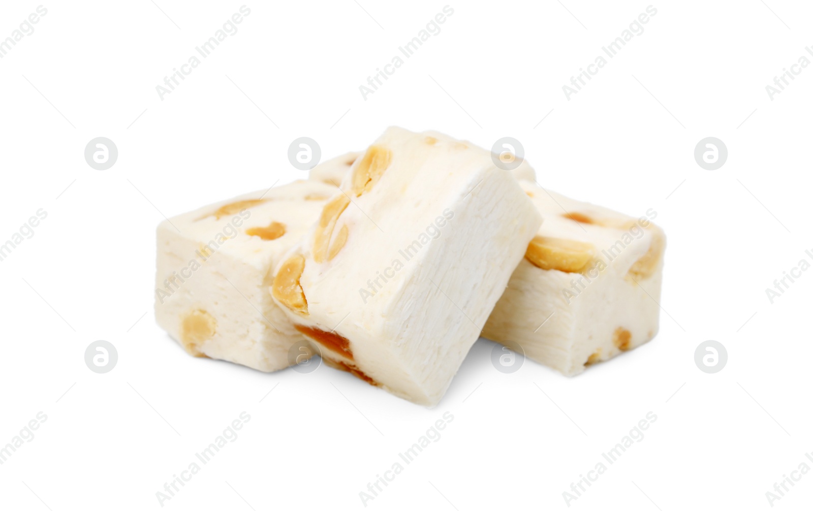 Photo of Many pieces of delicious nougat on white background