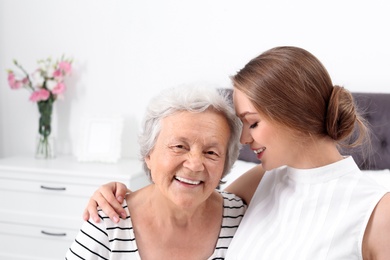 Happy young woman with her grandmother at home