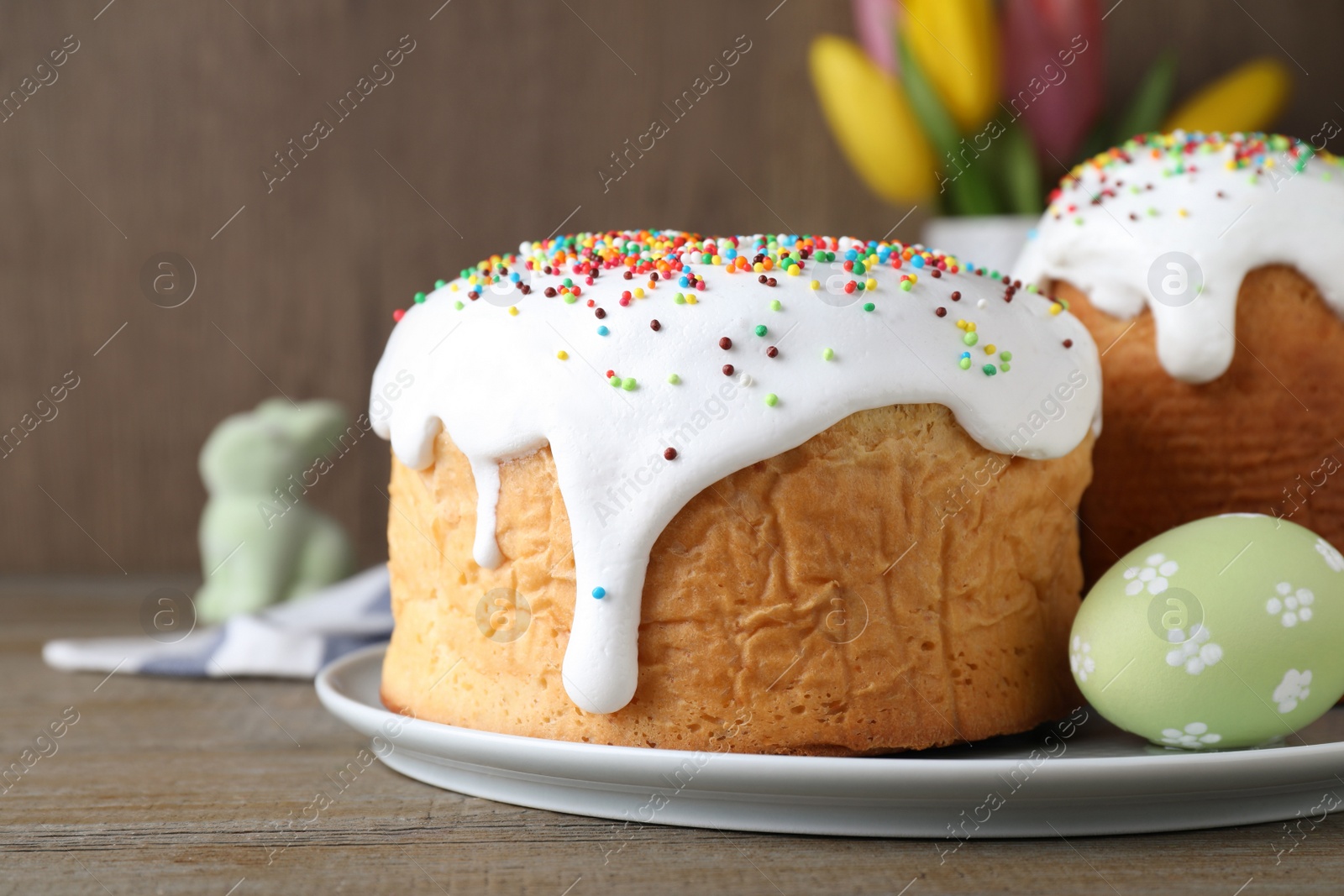 Photo of Easter cakes and color egg on wooden table, closeup