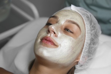 Beautiful woman with mask on her face in spa salon