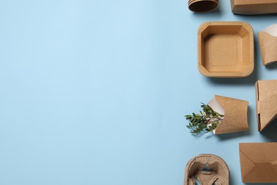 Photo of Flat lay composition with eco friendly food packagings and twigs on light blue background. Space for text