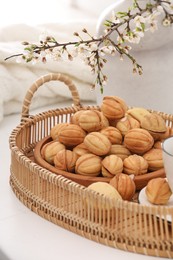 Photo of Delicious walnut shaped cookies with filling and cherry branch on white table. Homemade popular biscuits from childhood