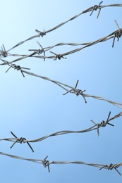 Metal barbed wire on light blue background