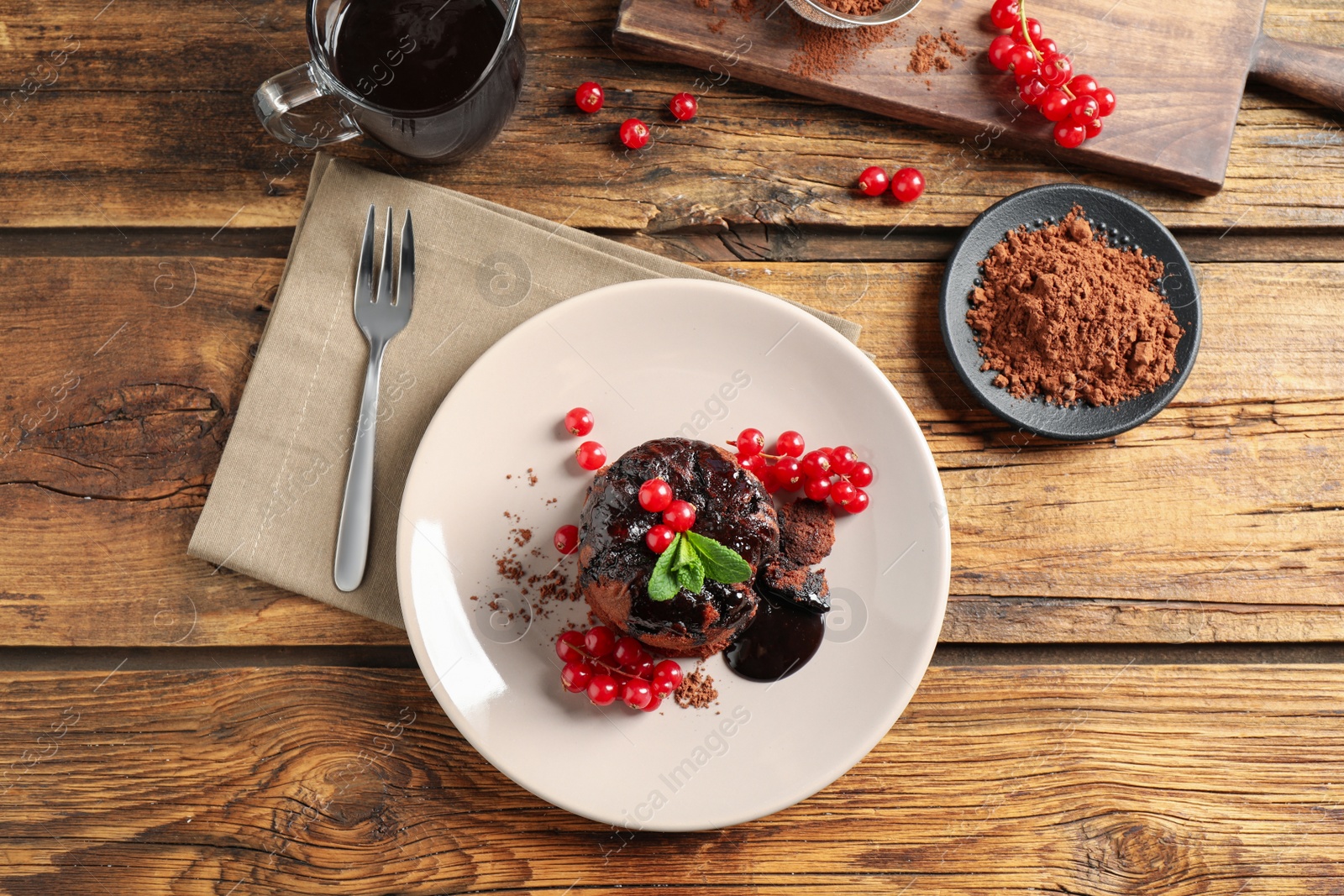 Photo of Delicious warm chocolate lava cake with mint and berries on wooden table, flat lay