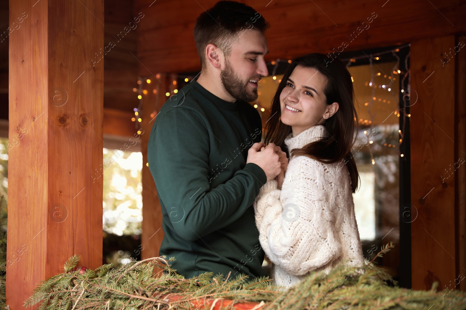 Photo of Happy couple in warm clothes on open terrace. Winter vacation